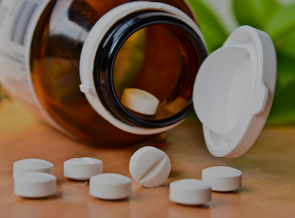 Closeup, pharmacy and medicine with healthcare, pills and shelf with boxes, bottles and treatment. Zoom, medication and package with container, retail and store with pharmaceutical, items or products